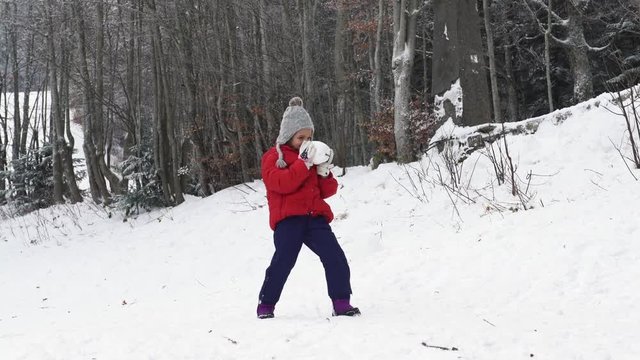 A little girl playing with the snow in the wild park, 4K