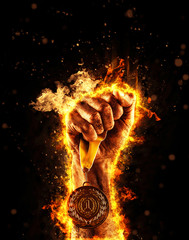 Man's hand in a fire is holding up gold medal. Winner in a competition.