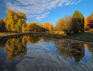 Beautiful autumn park with colorful trees reflected in the water.