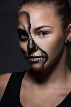 Halloween. Portrait of young beautiful girl with make-up skeleton on her face