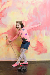 Obraz na płótnie Canvas Small girl listen music with mop.