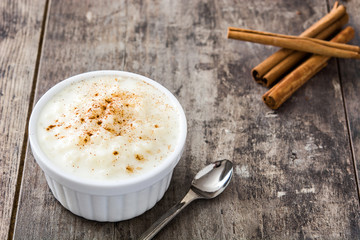 Arroz con leche. Rice pudding with cinnamon on wooden background
