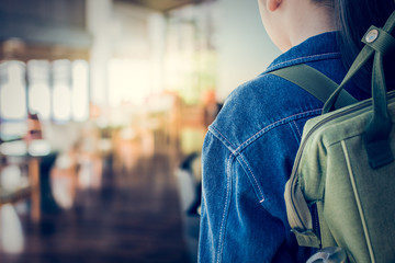 Girl with backpack entering to the classroom.