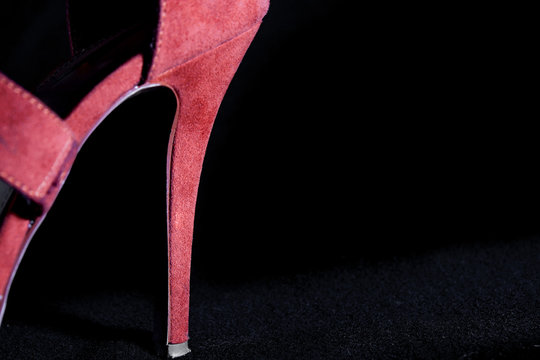 detail at red female high heels shoes on a black background