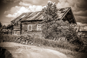 north Russian village Isady. Summer day, Emca river, old cottages on the shore, old wooden bridge. Abandoned building.