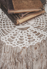 Vintage old books and lace fabric on the old wood