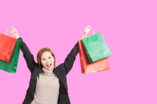 Shopper woman holding shopping bag on pastel ping background.