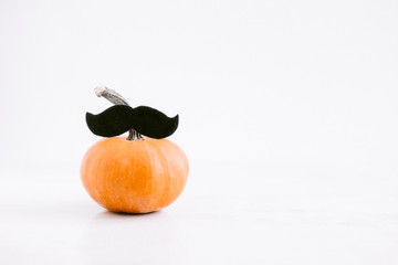 Little pumpkin with mustache on white background. Halloween, Movember event concept. Copyspace
