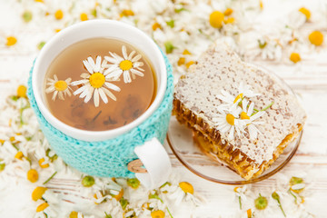 Obraz na płótnie Canvas Honeycomb and chamomile tea on white