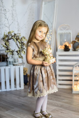 Merry Christmas and Happy Holidays! Cute little child girl play for the Christmas holidays indoors near Christmas tree