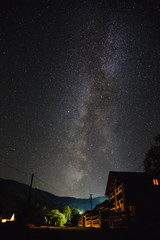 The Milky Way over the mountains and the village on a summer night.