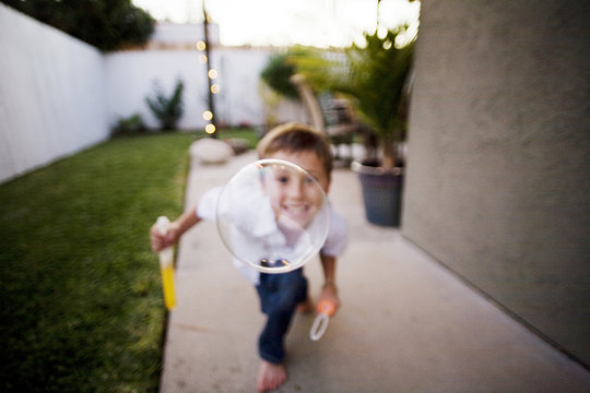 Boy Outdoors Looking Through a Bubble