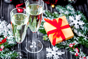 glasses of champagne and Christmas ornaments on dark wooden back