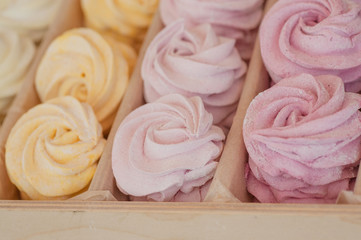 Delicious sweet biscuit meringue with an air cream of different colors in box for sale, inside a sweet shop