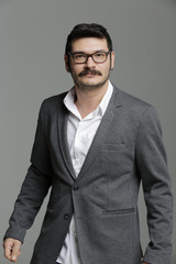 Portrait of a smiling young businessman on gray background