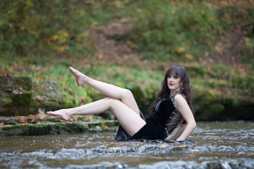 Brunette in a black dress in the water