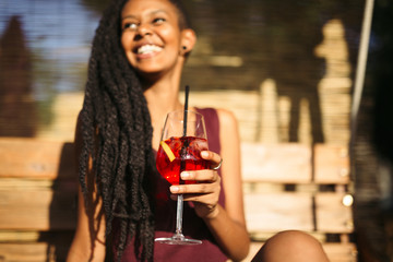 African woman having a drink outdoors