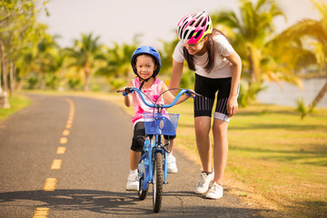 Mother teaching her daughter cycling