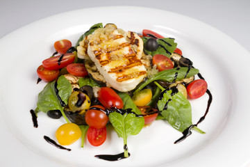 Grilled Halloumi Cheese poured with garlic olive oil salad witch grilled eggplant, cherry tomatoes, black olives and spinach. healthy food. Close up