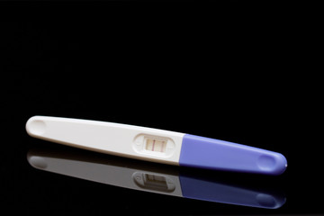 positive pregnancy test on black background