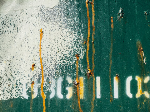 Detail of paint covering graffiti tags on metal wall
