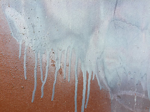 Detail of paint covering graffiti tags on metal wall