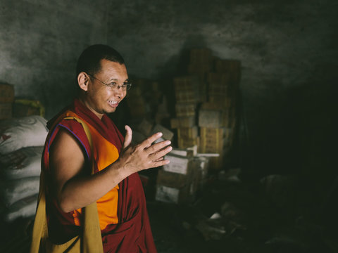 Happy Monk Standing in dark room