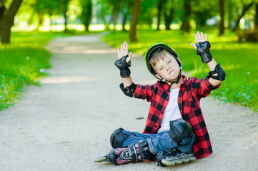 Fototapeta premium Funny boy in a protective helmet and protective pads for roller skating. Space for text