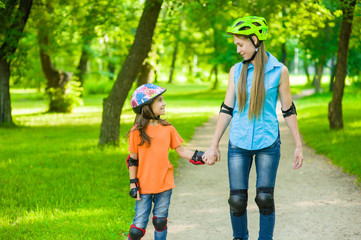 Mother and daughter have fun in nature, rollerblading