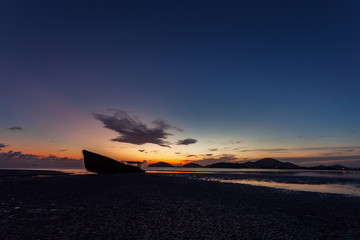 shipwreck on beach in the andaman sea with beautiful sunrise or sunset in phuket thailand.