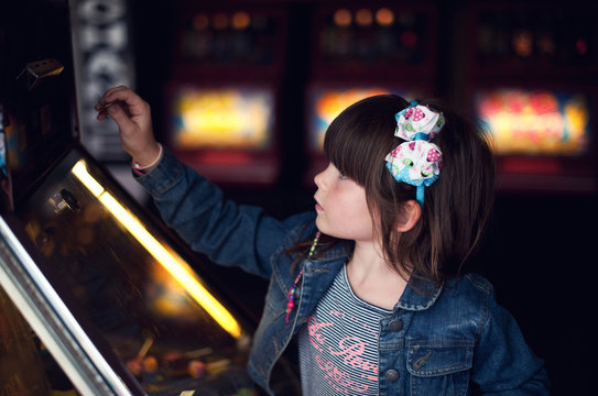 Little girl playing a penny slot machine