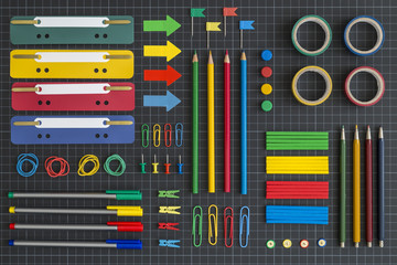 Multicolored office tools on dark background