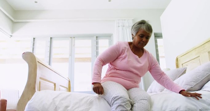 Senior woman having a huge stomach pain in bedroom 