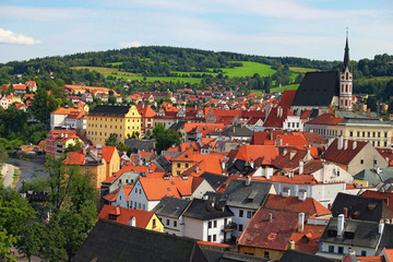 Fototapeta premium Red tile roofs cityscape. Church of Saint Vitus- UNESCO World Heritage Site. Summer sunny day. Cesky Krumlov (Krumau), Czech Republic