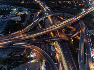 Fototapeta na wymiar Vertical top down aerial view of traffic on freeway interchange at night.