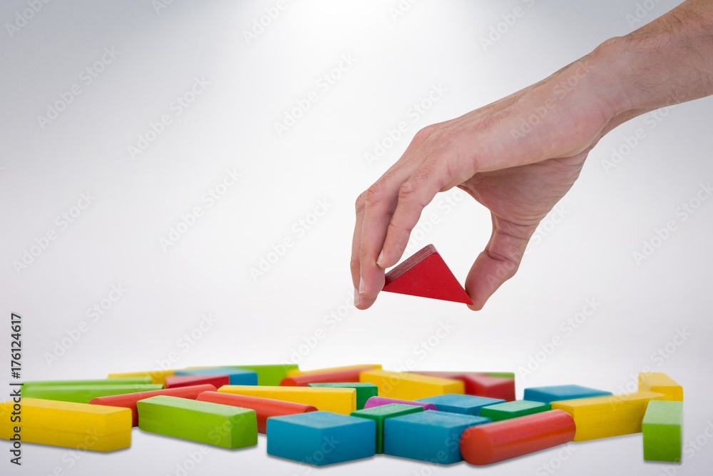 Poster composite image of cropped image of person arranging blocks
