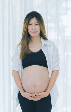 Beautiful pregnant woman touching care her belly