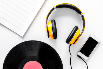 Accessories of contemporary composer. Headphones. phone, vinyl record, music notes on white background top view