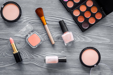 Cosmetics set with beige and nude tones for natural makeup on grey wooden background top view