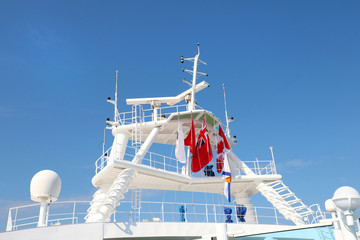 Radars and communications system on a cruise ship. flying flags of different countries.
