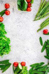 Healthy meal with vegetables tomato, cucumber, asparagus, salad, pea on grey background top view copyspace