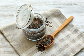 Chia seeds in jar and spoon on table