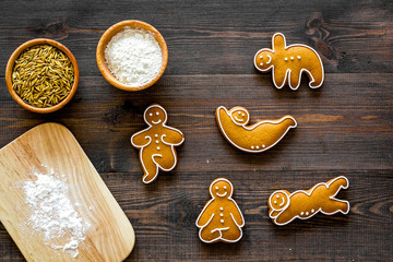 Make gluten free healthy food. Yoga asanas cookies near desk, flour and wheat on dark wooden...