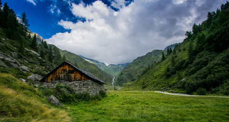 Fototapeta na wymiar Old malga at the bottom of a valley nearby Alps