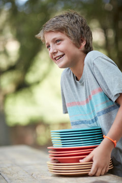 Child with a stack of colorful plates