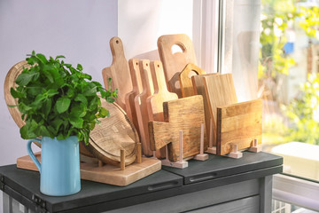 Fototapeta na wymiar Different wooden boards on table near window in kitchen