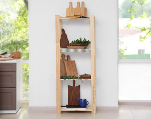 Storage stand with different wooden boards in kitchen