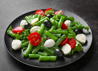 Plate of salad with green beans on table
