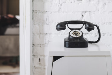 Old phone against white brickwall