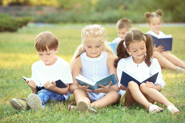 Fototapeta premium Cute little children reading books in park